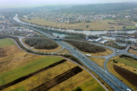 Aerial view of the A73 motorway junction and the Main Danube Canal winding through the landscape with residential areas and fields Forchheim Bavaria Germany.