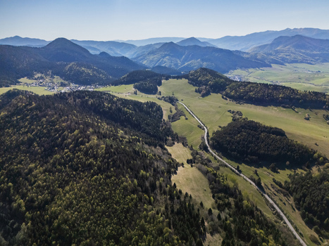 Aerial view of the village of Valaska Dubova nestled among lush green mountains and dense forests under a clear blue sky Valaska Dubova Zilina Region Slovakia. Aerial view of the village of Valaska Dubova nestled among lush green mountains and dense forests under a clear blue sky Valaska Dubova Zilina Region Slovakia.