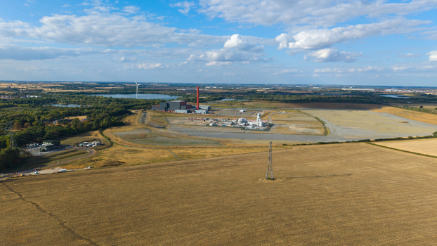 Aerial view of Millbrook Power Plant with its red chimney surrounded by open fields industrial infrastructure and distant lakes in Stewartby England United Kingdom. Aerial view of Millbrook Power Plant with its red chimney surrounded by open fields industrial infrastructure and distant lakes in Stewartby England United Kingdom.
