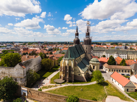 Aerial view of St. Nicholas Basilica with its twin towers and green copper roof surrounded by historic city walls and red roofed houses in Trnava Trnava Region Slovakia. Aerial view of St. Nicholas Basilica with its twin towers and green copper roof surrounded by historic city walls and red roofed houses in Trnava Trnava Region Slovakia.