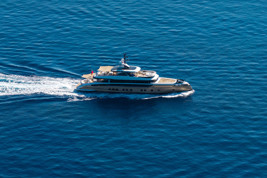 Aerial view of a luxury yacht cruising through the deep blue waters of the Mediterranean Sea near the coast of Le Trayas in Saint Raphael Provence Alpes Cote d Azur France. Aerial view of a luxury yacht cruising through the deep blue waters of the Mediterranean Sea near the coast of Le Trayas in Saint Raphael Provence Alpes Cote d Azur France.