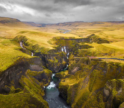 Aerial view of the Fjaðrá river snaking through the rugged canyon its waters a vibrant turquoise against the mossy green cliffs Fjaðrárgljúfur Skaftárhreppur Iceland. Aerial view of the Fjaðrá river snaking through the rugged canyon its waters a vibrant turquoise against the mossy green cliffs Fjaðrárgljúfur Skaftárhreppur Iceland.