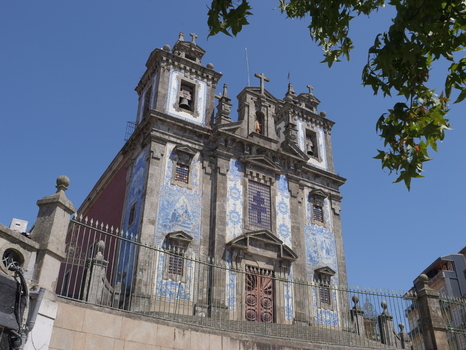 View of the historic Igreja de Santo Ildefonso featuring its iconic blue and white azulejo tile facade stone towers and ornate entrance in Porto Porto District Portugal. View of the historic Igreja de Santo Ildefonso featuring its iconic blue and white azulejo tile facade stone towers and ornate entrance in Porto Porto District Portugal.