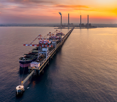 Aerial view of Orot Rabin Power Plant with a large coal ship docked at the pier during a vibrant sunset over the Mediterranean Sea in Hadera Haifa District Israel. Aerial view of Orot Rabin Power Plant with a large coal ship docked at the pier during a vibrant sunset over the Mediterranean Sea in Hadera Haifa District Israel.