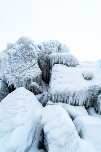 View of ice covered rocks near the Molenfeuer Sassnitz featuring thick icicles and frozen textures on the breakwater structures in Sassnitz Mecklenburg Vorpommern Germany.