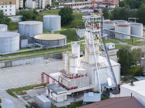 Aerial view of the Wieliczka Salt Mine industrial site featuring a tall mine shaft tower white silos and large storage tanks in Wieliczka Lesser Poland Voivode Poland.