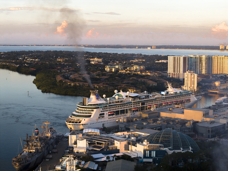 Tampa Florida United States 04 July 2026 Aerial view of Tampa Cruise Terminal 6 with a cruise ship docked smoke from the funnel urban buildings and water at sunset.