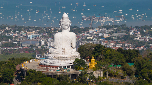 Aerial view of the Big Buddha Phuket statue overlooking the coastal town and a bay filled with boats Karon Phuket Thailand. Aerial view of the Big Buddha Phuket statue overlooking the coastal town and a bay filled with boats Karon Phuket Thailand.