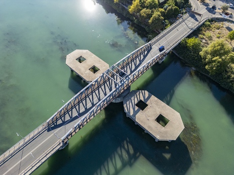 Aerial view of Ura e re e Bunes bridge spanning the turquoise waters of the Buna River with concrete support structures and surrounding greenery in Shkoder Qarku i Shkodres Albania. Aerial view of Ura e re e Bunes bridge spanning the turquoise waters of the Buna River with concrete support structures and surrounding greenery in Shkoder Qarku i Shkodres Albania.