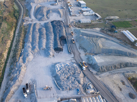 Aerial view of a gravel quarry with large piles of crushed stone industrial machinery and trucks driving along a dirt road in Istanbul Istanbul Turkiye.