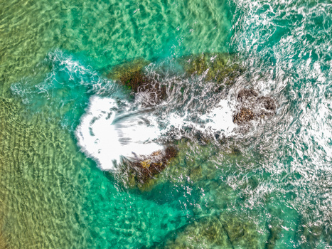 Aerial view of Cudgen Headland South Head surrounded by turquoise ocean water with white sea foam crashing against the rocks in Kingscliff New South Wales Australia. Aerial view of Cudgen Headland South Head surrounded by turquoise ocean water with white sea foam crashing against the rocks in Kingscliff New South Wales Australia.