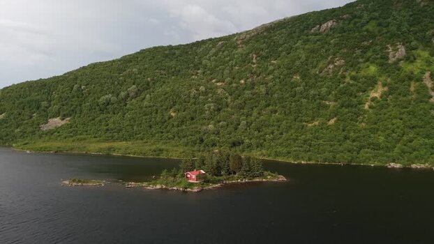 Aerial view of a red house on a small island in Senja Norway.