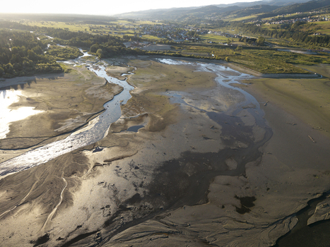 Aerial view of Lake Czorsztynskie showing low water levels with exposed riverbed winding stream surrounding hills and distant village in Nowy Targ County Lesser Poland Voivode Poland. Aerial view of Lake Czorsztynskie showing low water levels with exposed riverbed winding stream surrounding hills and distant village in Nowy Targ County Lesser Poland Voivode Poland.