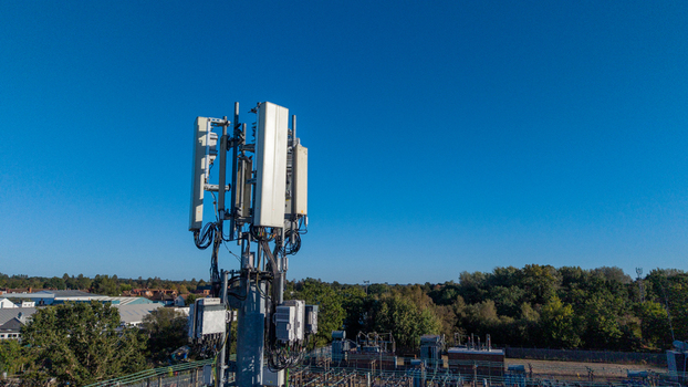 Aerial view of a telecommunications mast with antennas and equipment against a clear blue sky in Camberley England United Kingdom. Aerial view of a telecommunications mast with antennas and equipment against a clear blue sky in Camberley England United Kingdom.