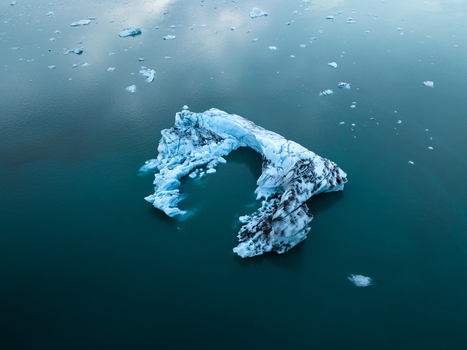 Aerial view of an iceberg with striking blue and white hues floating serenely in the glacial lagoon Jokulsarlon Iceland. Aerial view of an iceberg with striking blue and white hues floating serenely in the glacial lagoon Jokulsarlon Iceland.