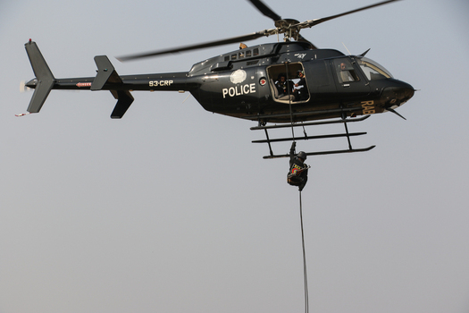 Dhaka Bangladesh 01 February 2017 View of a Rapid Action Battalion RAB police helicopter with an officer rappelling down a rope during a demonstration at the RAB Headquarters. Dhaka Bangladesh 01 February 2017 View of a Rapid Action Battalion RAB police helicopter with an officer rappelling down a rope during a demonstration at the RAB Headquarters.