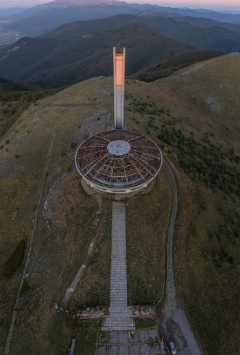 Aerial view of the Buzludzha Monument with its iconic circular roof and tall tower set against the mountainous landscape of Stara Zagora Bulgaria. Aerial view of the Buzludzha Monument with its iconic circular roof and tall tower set against the mountainous landscape of Stara Zagora Bulgaria.