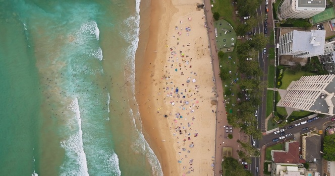 Aerial view of a crowded beach with turquoise waves golden sand and coastal buildings in Sydney New South Wales Australia. Aerial view of a crowded beach with turquoise waves golden sand and coastal buildings in Sydney New South Wales Australia.