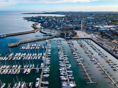 Aerial view of Bangor Harbour and Town featuring numerous yachts and boats moored in the marina set against the coastal urban landscape of Bangor Northern Ireland United Kingdom.