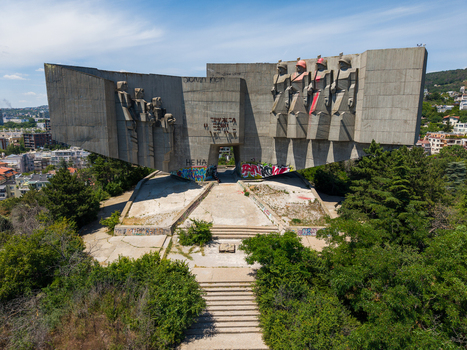 Aerial view of the Monument of the Bulgarian Soviet Friendship a massive concrete brutalist structure with sculpted figures surrounded by trees and urban landscape in Varna Varna Bulgaria.