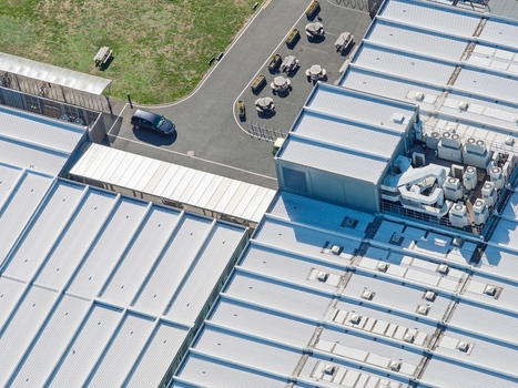 Aerial view of the Data Center at Oxford University featuring industrial rooftops HVAC units a parking area with outdoor seating and a car in Oxford England United Kingdom. Aerial view of the Data Center at Oxford University featuring industrial rooftops HVAC units a parking area with outdoor seating and a car in Oxford England United Kingdom.
