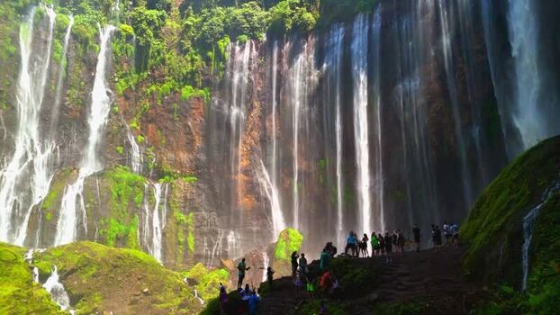 Aerial view of Tumpak Sewu Waterfall and lush cliffs Indonesia.