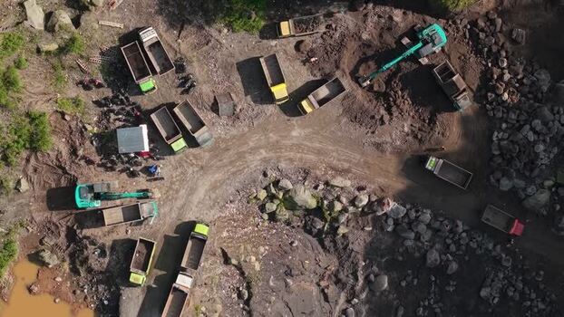 Aerial view of excavators and trucks at a sand mine Indonesia.