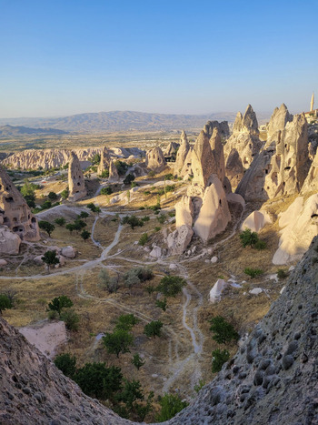 View of the unique fairy chimneys and volcanic rock formations in Cappadocia under a clear blue sky during golden hour Turkiye. View of the unique fairy chimneys and volcanic rock formations in Cappadocia under a clear blue sky during golden hour Turkiye.