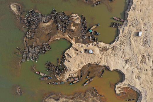 Aerial view of the Jadukata River with numerous wooden boats moored along the sandy riverbanks in Sunamganj Sylhet Division Bangladesh. Aerial view of the Jadukata River with numerous wooden boats moored along the sandy riverbanks in Sunamganj Sylhet Division Bangladesh.