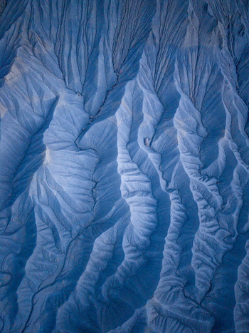 Aerial view of the intricate erosion patterns and deep gullies of the badlands in Caineville Utah United States. Aerial view of the intricate erosion patterns and deep gullies of the badlands in Caineville Utah United States.
