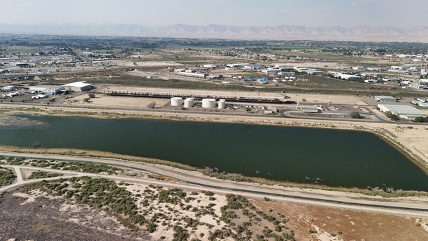 Grand Junction United States 03 July 2026 Aerial view of retention ponds surrounded by arid landscape industrial infrastructure and distant mountains.