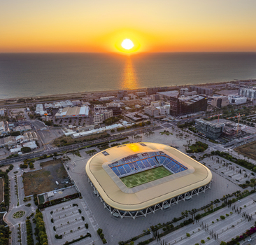 Aerial view of Sammy Ofer Stadium at sunset with the Mediterranean Sea in the background urban cityscape and golden light in Haifa Haifa District Israel.