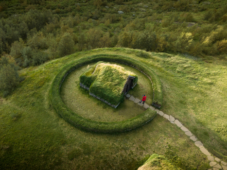 Aerial view of a turf house nestled within a circular earthwork blending seamlessly into the verdant landscape Selfoss Skeiða og Gnúpverjahreppur Iceland. Aerial view of a turf house nestled within a circular earthwork blending seamlessly into the verdant landscape Selfoss Skeiða og Gnúpverjahreppur Iceland.