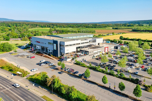 Bamberg Germany 02 May 2026 Aerial view of Brose Arena surrounded by a large parking lot lush green fields and dense forests under a clear blue sky. Bamberg Germany 02 May 2026 Aerial view of Brose Arena surrounded by a large parking lot lush green fields and dense forests under a clear blue sky.