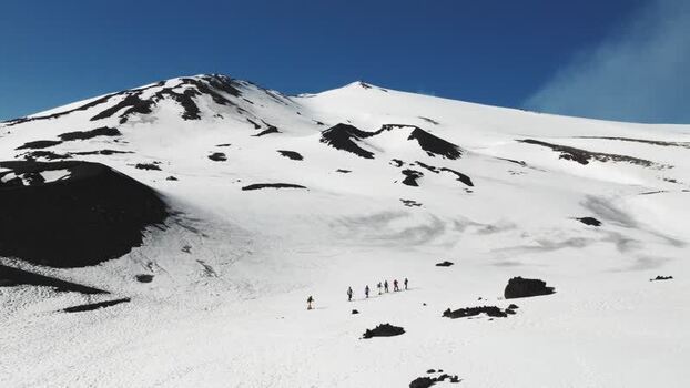 Aerial view of hikers on the snowy slopes of Mount Etna Italy. Aerial view of hikers on the snowy slopes of Mount Etna Italy.