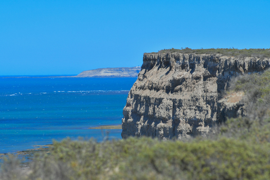 View of the steep coastal cliffs of Puerto Piramides overlooking the turquoise waters of the Atlantic Ocean under a clear blue sky Puerto Madryn Chubut Argentina. View of the steep coastal cliffs of Puerto Piramides overlooking the turquoise waters of the Atlantic Ocean under a clear blue sky Puerto Madryn Chubut Argentina.