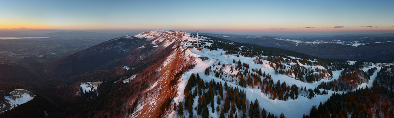 Aerial view of snow dusted forests meet the golden embrace of the setting sun at Mont Rond s peak Gex Auvergne Rh&ocirc;ne Alpes France.