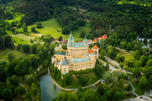 Aerial view of Bojnice Castle surrounded by lush green parkland and trees in Prievidza Trenciansky kraj Slovakia.