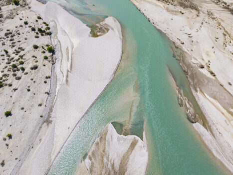 Aerial view of the turquoise waters of the Vjosa River winding through the white gravel banks of Vjosa Wild River National Park in Permet Gjirokaster County Albania. Aerial view of the turquoise waters of the Vjosa River winding through the white gravel banks of Vjosa Wild River National Park in Permet Gjirokaster County Albania.