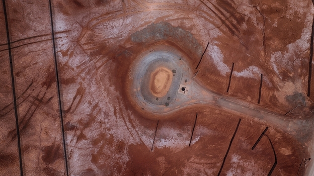Aerial view of the unique red salt pans with circular structures and tire tracks on the dry earth in Cagliari Sardinia Italy. Aerial view of the unique red salt pans with circular structures and tire tracks on the dry earth in Cagliari Sardinia Italy.