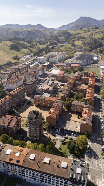 Aerial view of the residential area with its characteristic red tiled rooftops apartment blocks and surrounding green hills in Zumaia Basque Country Spain.