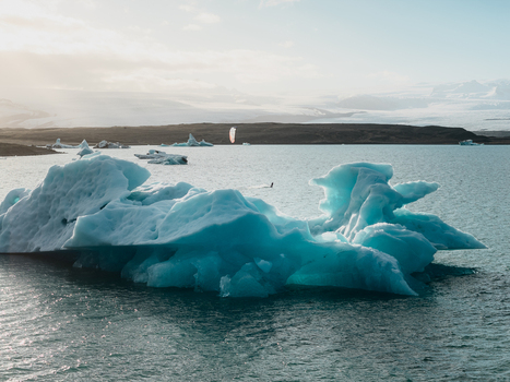 Aerial view of Jokulsarlon glacier lagoon featuring bright blue icebergs floating in calm water with a distant glacier under soft daylight in Sveitarfelagid Hornafjordur Iceland. Aerial view of Jokulsarlon glacier lagoon featuring bright blue icebergs floating in calm water with a distant glacier under soft daylight in Sveitarfelagid Hornafjordur Iceland.