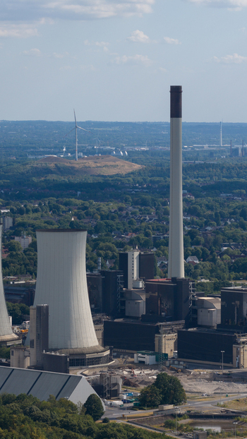 Aerial view of Scholven Power Station featuring its iconic cooling tower and tall chimney amidst the industrial landscape of Gelsenkirchen Nordrhein Westfalen Germany.