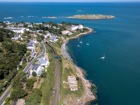 Aerial view of the Dalkey coastline featuring the historic EIRE sign railway tracks coastal houses and boats in the Irish Sea in Dublin County Dublin Ireland. Aerial view of the Dalkey coastline featuring the historic EIRE sign railway tracks coastal houses and boats in the Irish Sea in Dublin County Dublin Ireland.