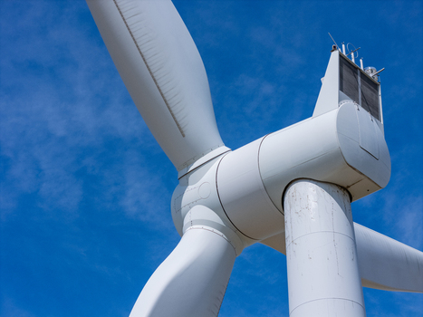 Aerial view of a modern white wind turbine against a clear blue sky in Lakeshore Ontario Canada. Aerial view of a modern white wind turbine against a clear blue sky in Lakeshore Ontario Canada.