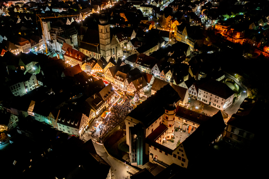 Forchheim Germany 20 December 2025 Aerial view of the Weihnachtsmarkt Forchheim at night with illuminated stalls historic half timbered houses and crowds of people in the old town.