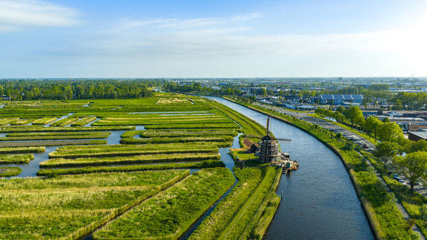 Aerial view of the historic Oosterdel landscape with its unique water channels and a traditional windmill under renovation along a canal Broek op Langedijk Noord Holland Netherlands. Aerial view of the historic Oosterdel landscape with its unique water channels and a traditional windmill under renovation along a canal Broek op Langedijk Noord Holland Netherlands.