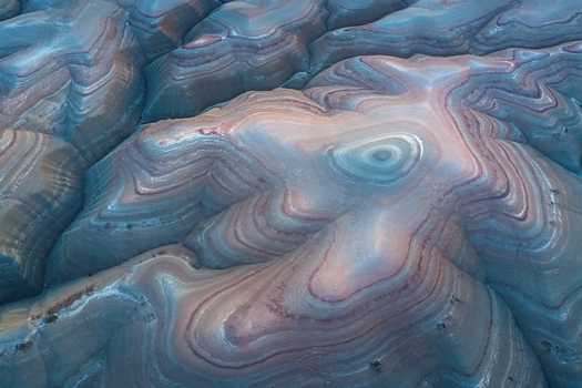 Aerial view of the mesmerizing layered earth reveals a tapestry of swirling blues reds and browns creating an otherworldly landscape of textured beauty Hanksville Utah United States. Aerial view of the mesmerizing layered earth reveals a tapestry of swirling blues reds and browns creating an otherworldly landscape of textured beauty Hanksville Utah United States.