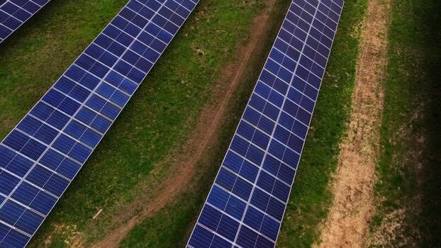 Aerial view of solar panels on green grass United States.