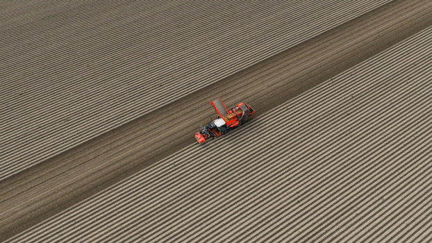Zeewolde Flevoland Netherlands 02 September 2026 Aerial view of a potato harvester working in a large plowed field with distinct furrows. Zeewolde Flevoland Netherlands 02 September 2026 Aerial view of a potato harvester working in a large plowed field with distinct furrows.